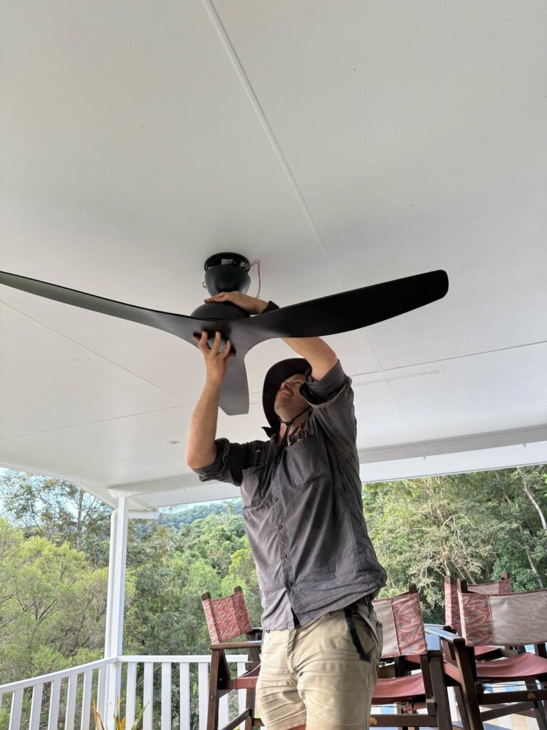electrician installing claro whisper ip66 58 inch ceiling fan in outdoor area cairns
